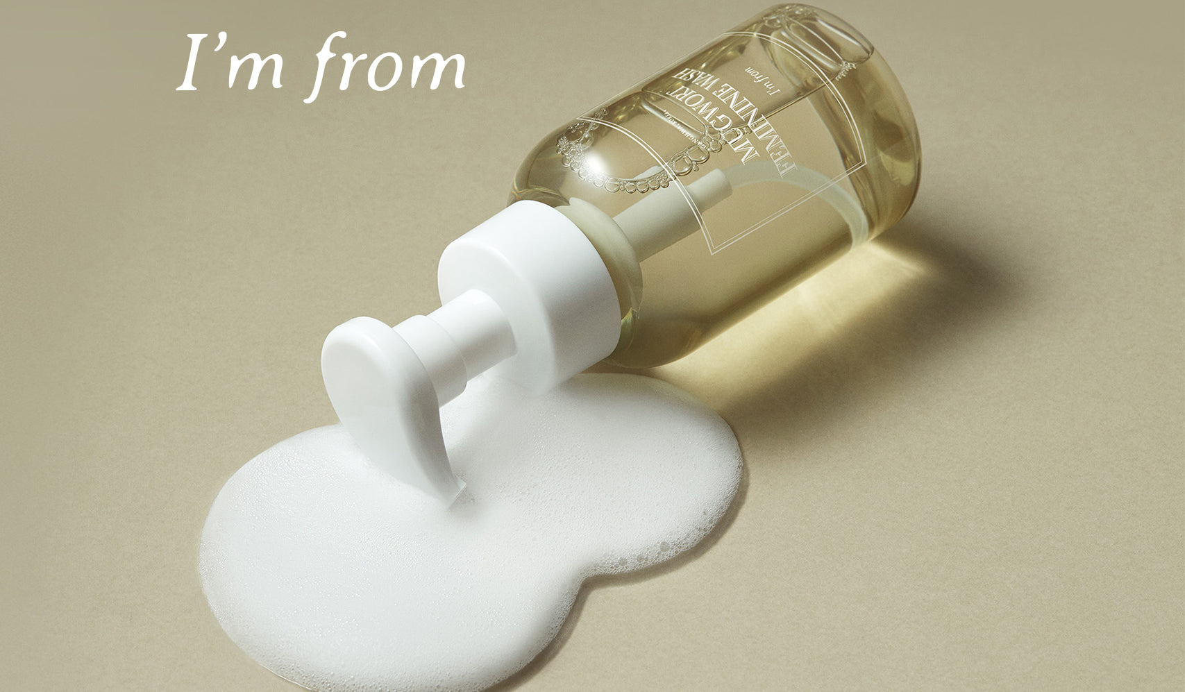 Flacon de soin peau I'M FROM : La Magie des Ingrédients Naturels pour la Peau renversé avec mousse blanche