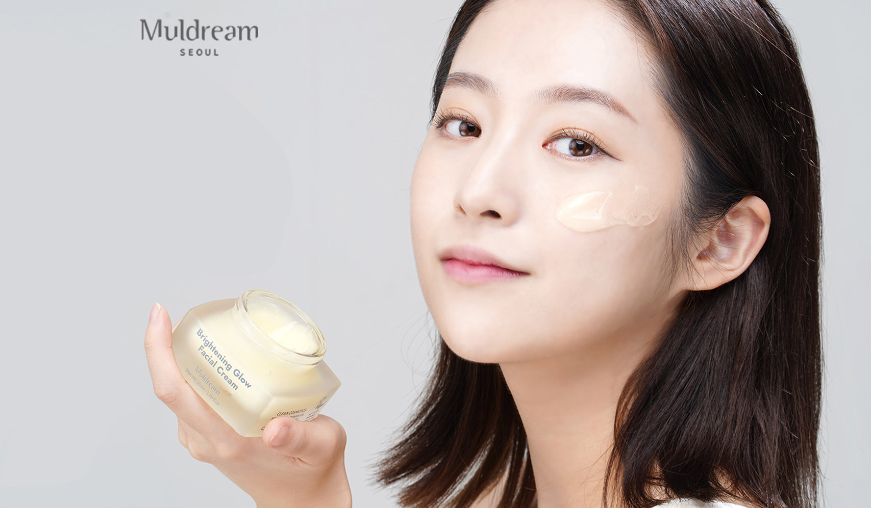 Modèle appliquant la crème Muldream, représentant L'Univers Réconfortant de MULDREAM, soins de la peau coréens