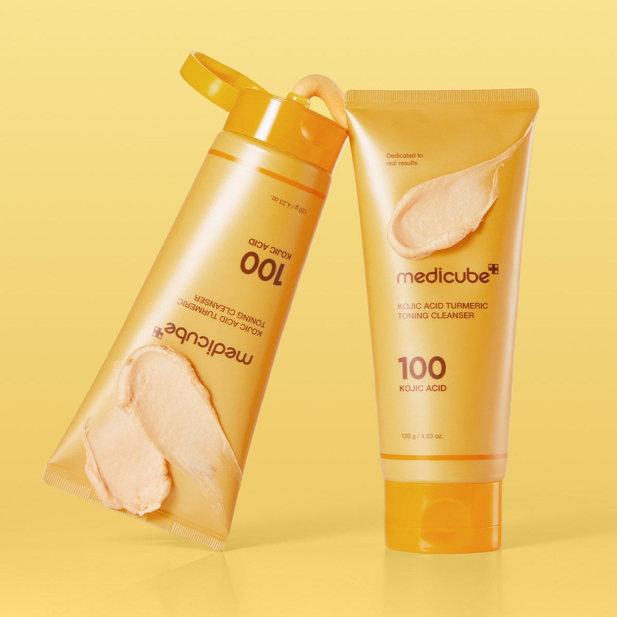 Deux tubes de MEDICUBE Kojic Acid Turmeric Vita Whip Cleanser 120g sur fond jaune, nettoyant visage éclaircissant avec kojic et curcuma.