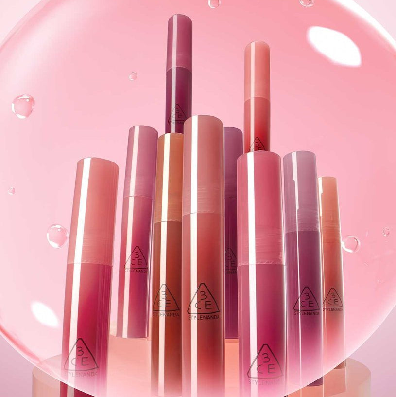 3CE Drop Glow Gel 10 Shades : tubes gloss couleur sur fond rose lumineux, gouttes et reflets, packshot beauté