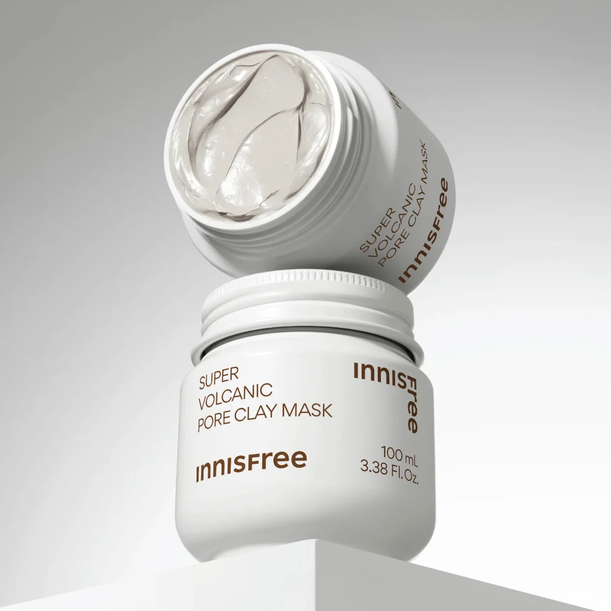 INNISFREE Super Volcanic Pore Clay Mask 100ml, masque à l’argile volcanique INNISFREE, pot ouvert et texture grise sur fond clair