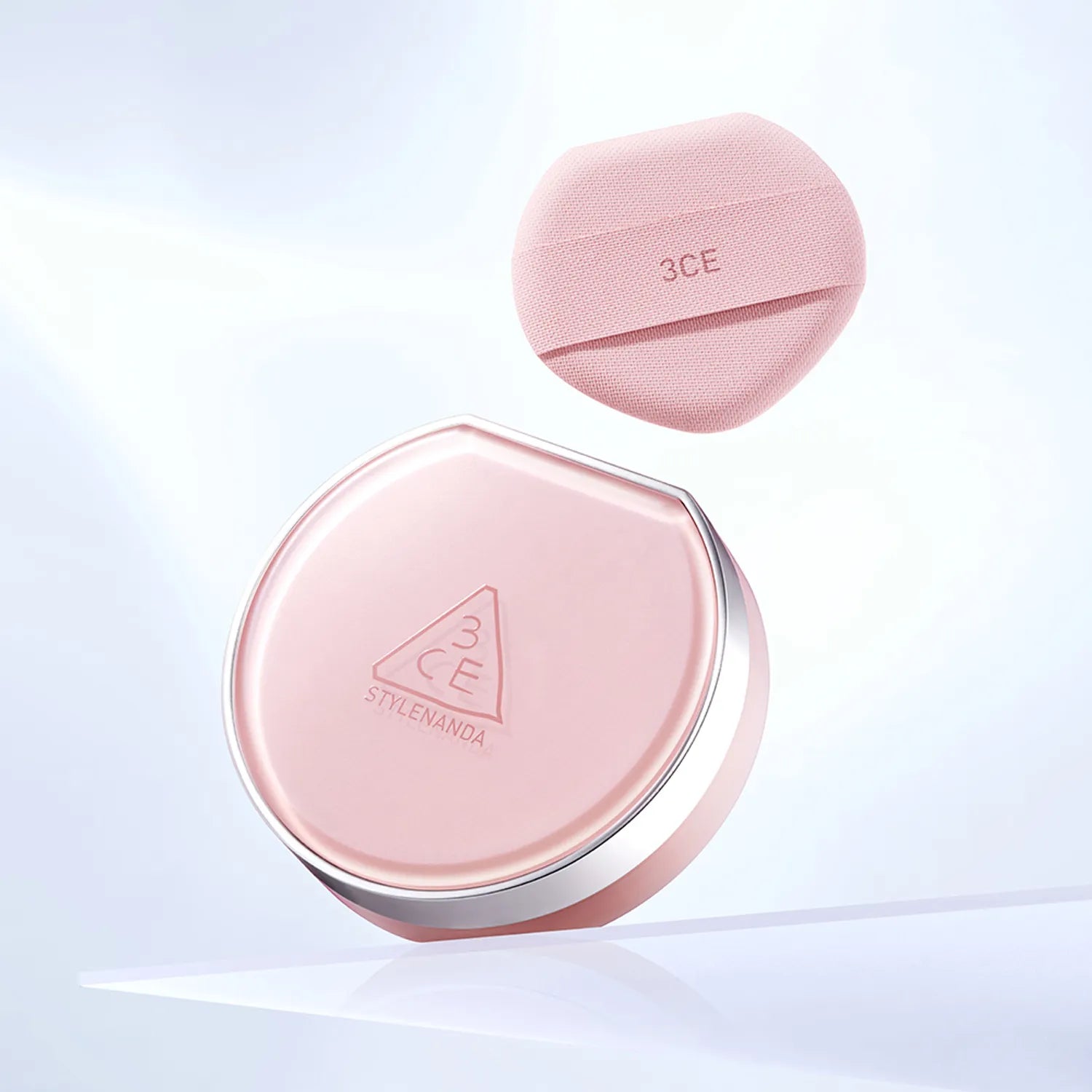 3CE Fitting Mesh Cushion SPF40, PA+++ 11g + Refill 11g, coussin compact rose 3CE sur fond lumineux, flacon et recharge