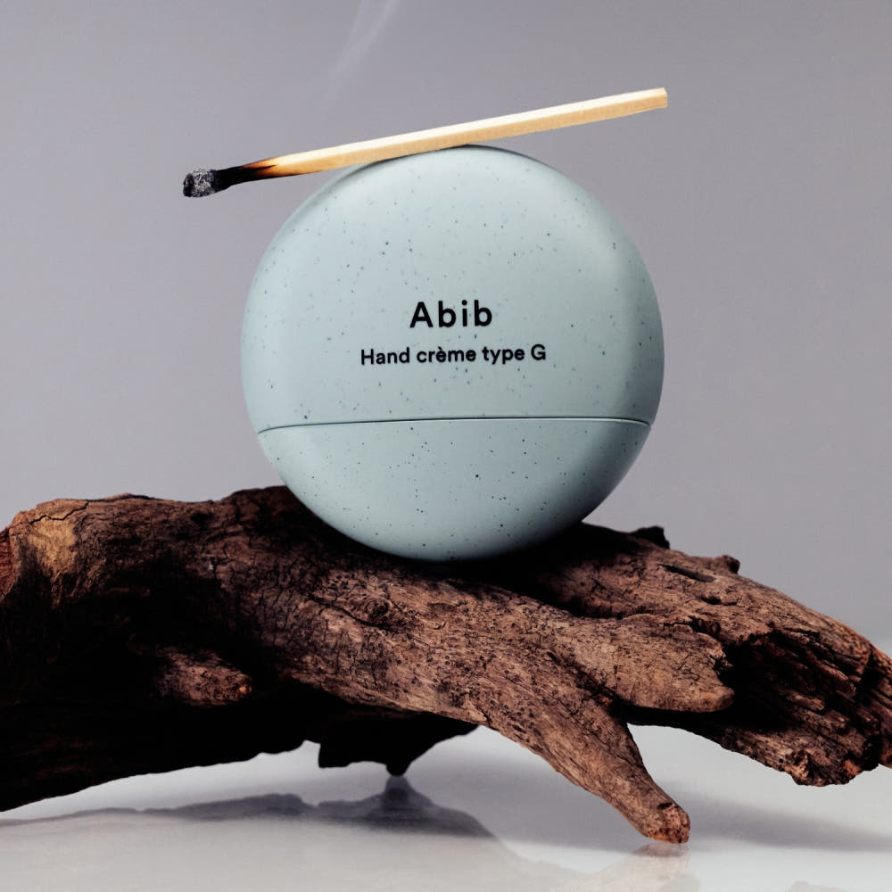 ABIB Hand Cream Type G 50ml, crème mains Abib sur bois et branche, contexte naturel, pack rond blanc