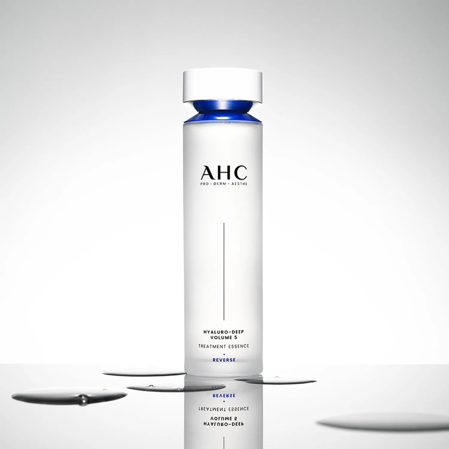 AHC Hyaluro Deep Volume 5 Treatment Essence 130ml, flacon blanc et bleu sur fond clair, gouttes d’essence