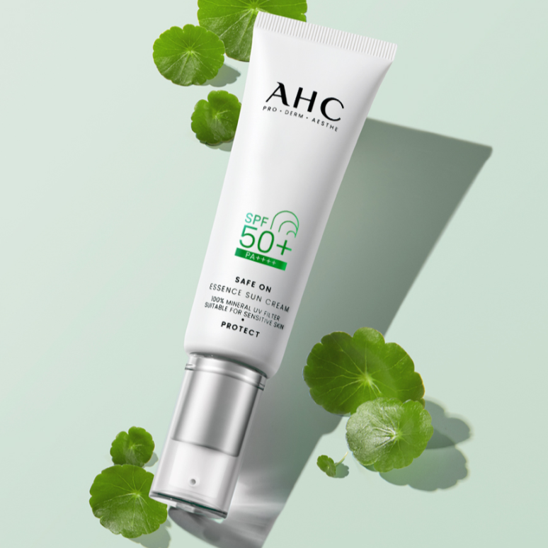AHC Safe On Essence Sunscreen 50ml, tube AHC sur fond vert avec feuilles, crème solaire SPF50.