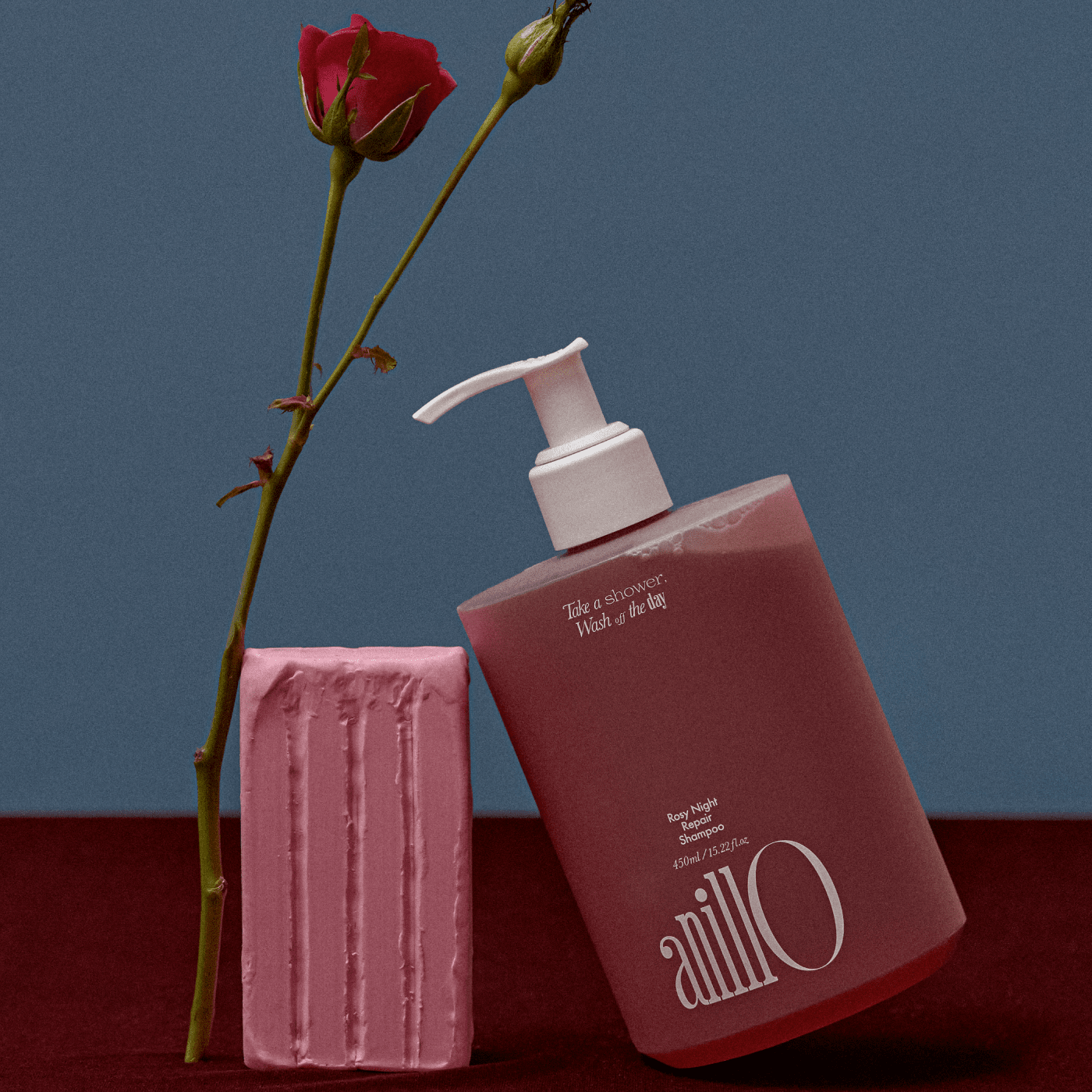 ANILLO Rosy Night Repair Shampoo 450ml en flacon rose, présenté sur fond bleu avec bougie et fleurs, marque ANILLO