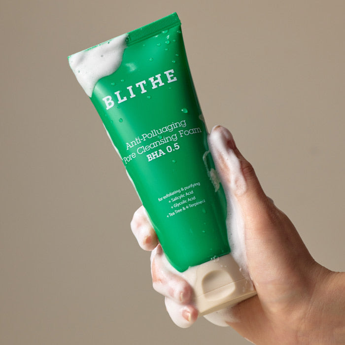 BLITHE Anti-Pollution Aging Pore Cleansing Foam BHA 0.5 150ml, tube vert BLITHE en main sur fond beige, anti-pollution