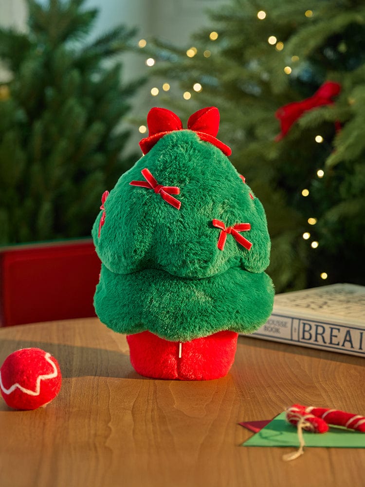 BT21 COOKY minini TREE PLUSH PETITE HOLIDAY, peluche COOKY de BTS posée près d’un sapin, décor de Noël.