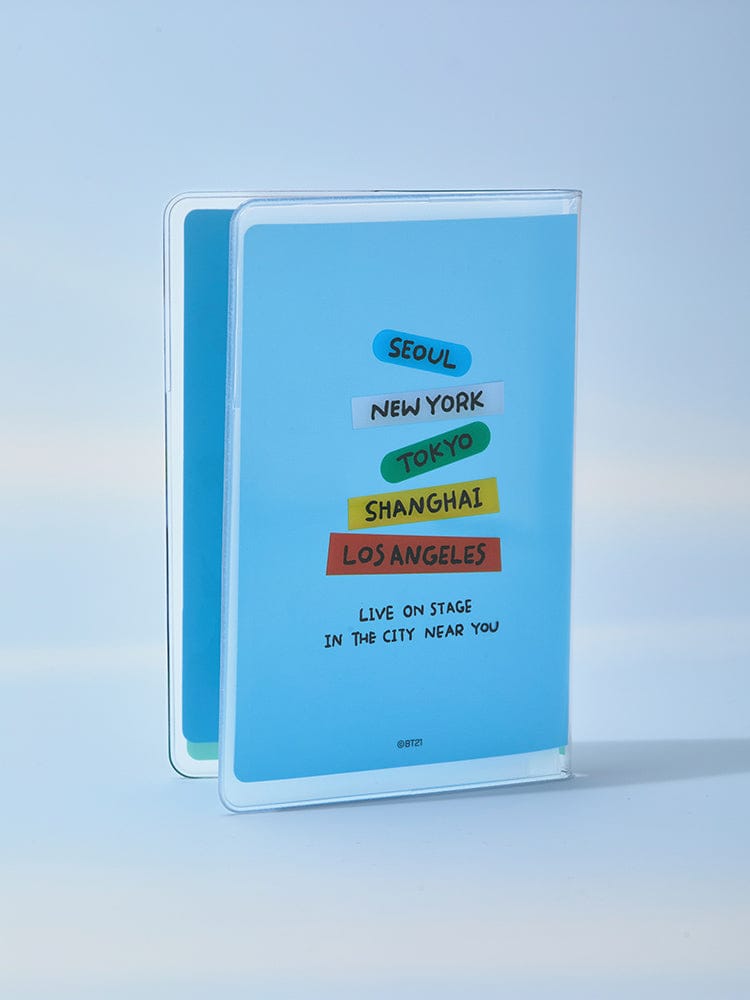 BT21 PASSPORT COVER WORLD VOYAGE LINE FRIENDS : protège-passeport bleu avec villes Seoul New York Tokyo Tokyo, sur fond clair.
