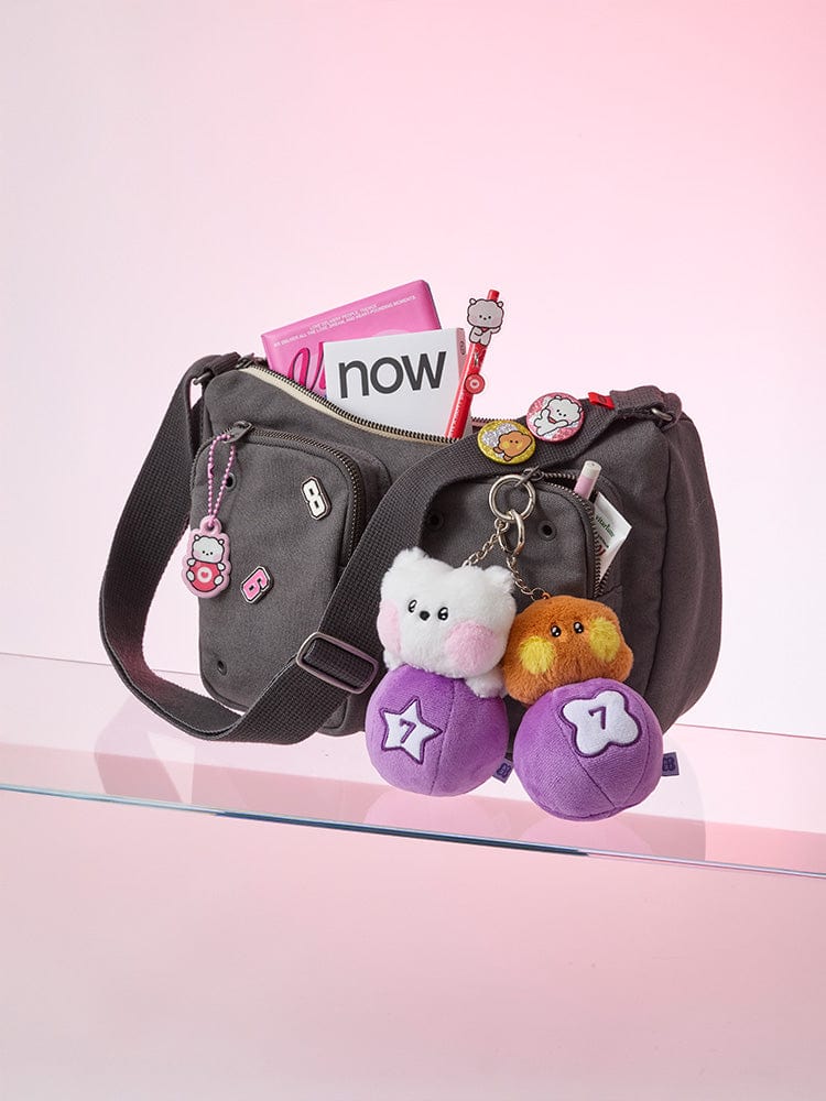 BT21 RJ minini PLUSH KEYRING LUCKY GATCHA : porte-clés peluche RJ sur sac noir, décor K-pop, fond rose pastel.