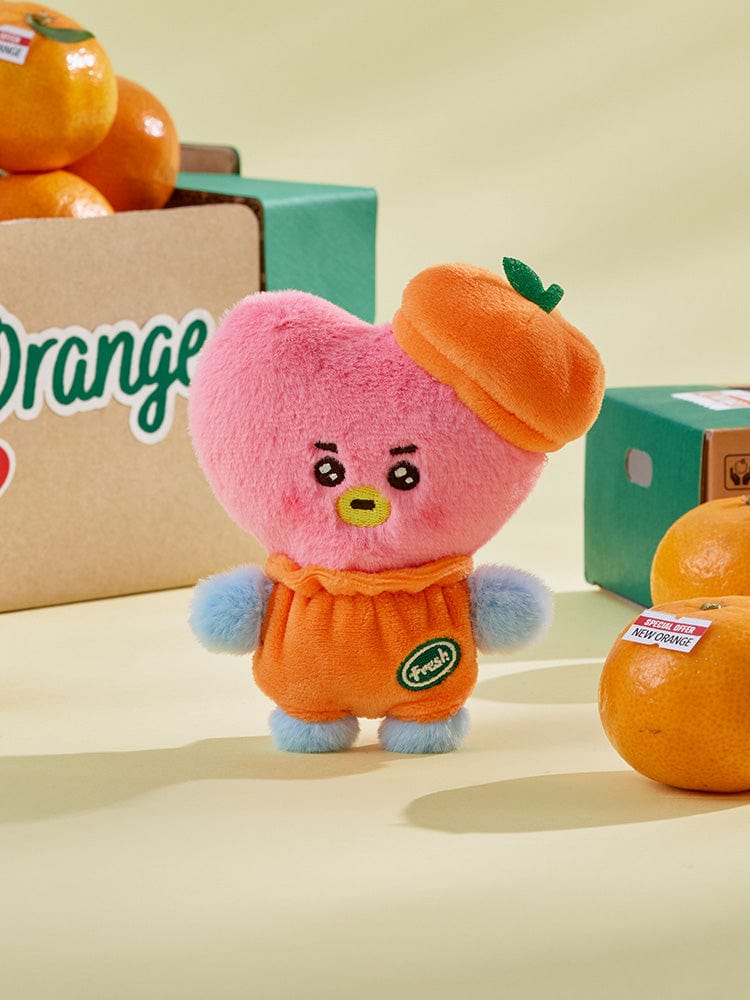 BT21 TATA BABY PLUSH ORANGE PARTY, peluche orange V de BTS, sur étagère, contexte déco chambre, près du packaging