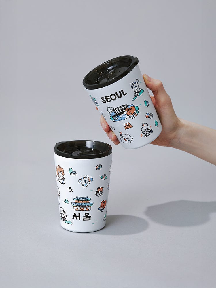 BT21 TUMBLER SEOUL EDITION (11oz) LINE FRIENDS : gobelet kawaii blanc « Seoul » avec couvercle noir, main en photo studio.