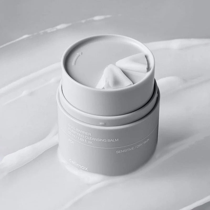 Décris l'image en français : CELIMAX Dual Barrier Purifying Cleansing Balm 50ml de la marque, sur tissu blanc en studio.