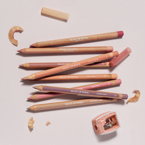 CLIO Velvet Lip Pencil, crayons à lèvres sur fond beige avec taille-crayon et pointes, rendu maquillage - CLIO