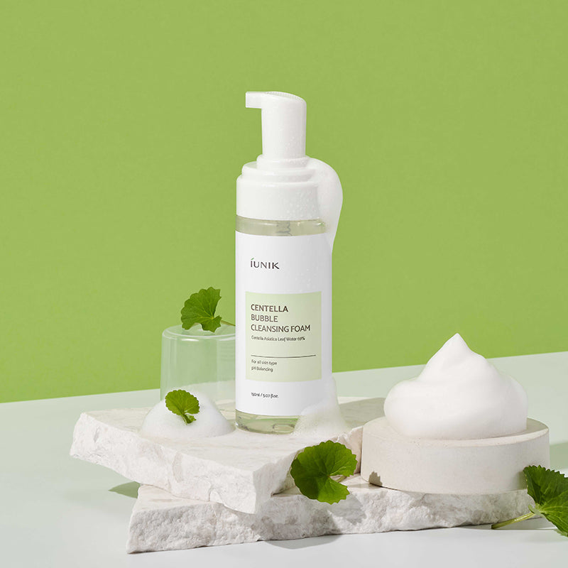 iUNIK Centella Bubble Cleansing Foam 150ml, la mousse nettoyante avec vapeur blanche et feuilles de centella sur fond vert.