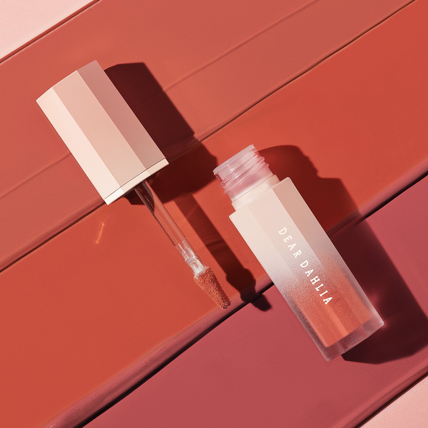 Rouge à lèvres DEAR DAHLIA Blooming Edition Petal Touch Plumping Lip Velour ouvert sur fond rose