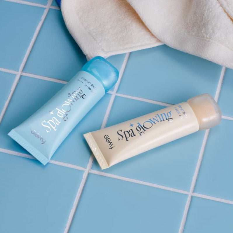 Produits de beauté FWEE Puy Spa Glowing UV Tone-Up Base 35ml sur carrelage bleu pour soin de la peau et protection UV.