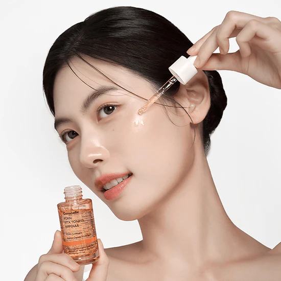GENABELLE PDRN Vita Toning Ampoule 30ml : femme applique avec pipette, sérum vitaminé Genabelle sur fond blanc.