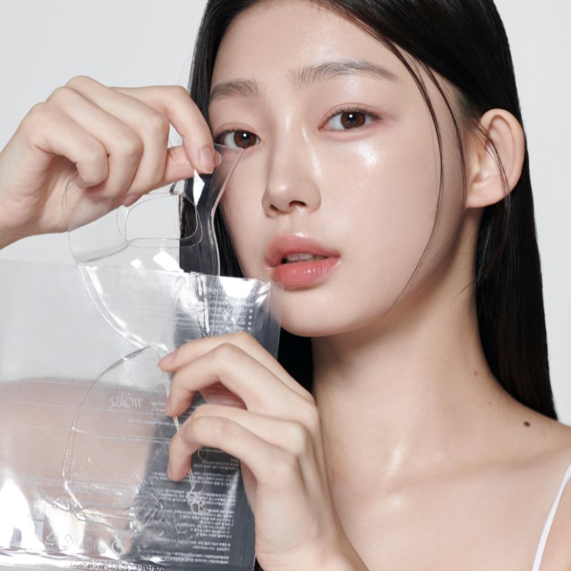 GLOW Aloe Hydrogel Mask Pack 3ea, marque GLOW : jeune femme applique un masque hydrogel à l’aloe, pack en main, ambiance soin