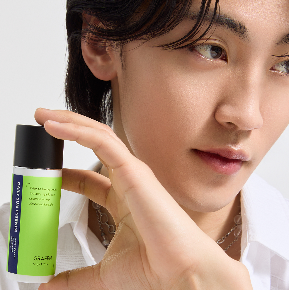 GRAFEN Daily Sun Essence 52g : sérum visage vert, jeune femme l’applique en studio sur fond clair (marque GRAFEN).