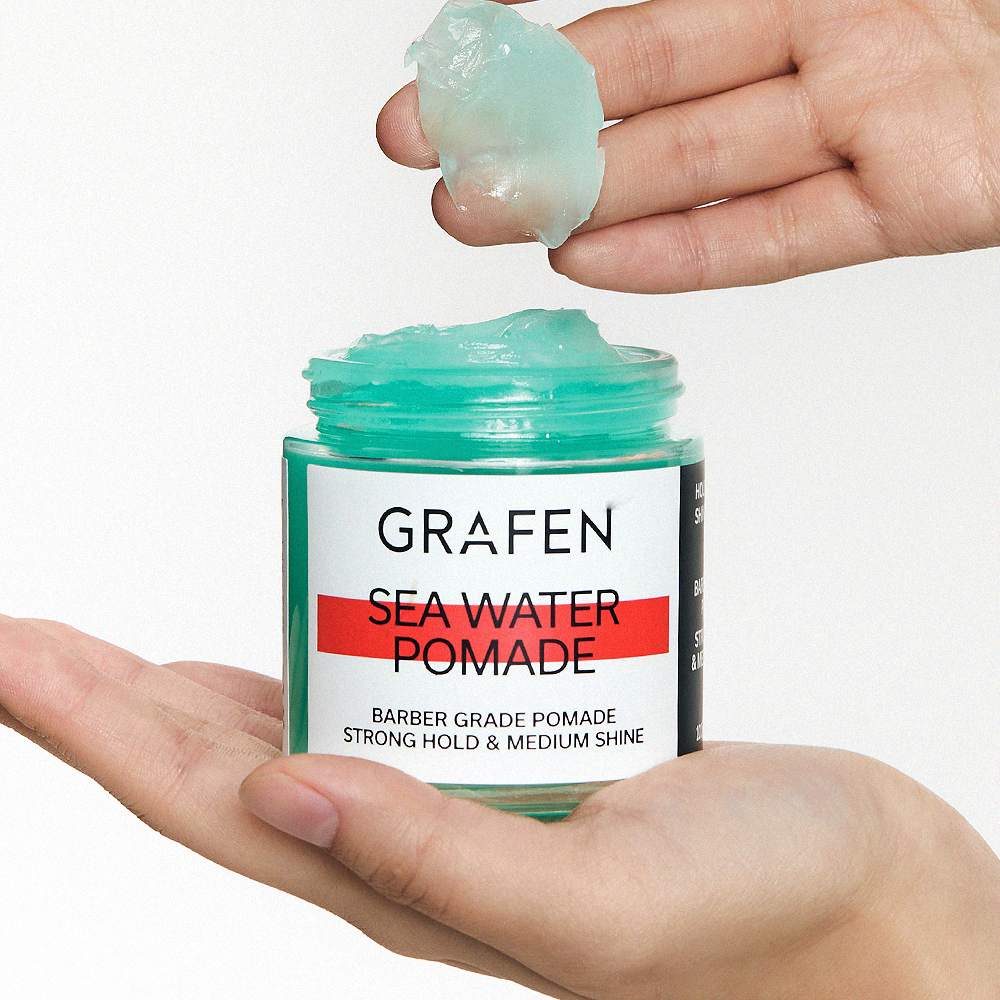 GRAFEN Sea Water Pomade 100g : pot vert tenue moyen, main tenant une noisette, contexte salle de bain.
