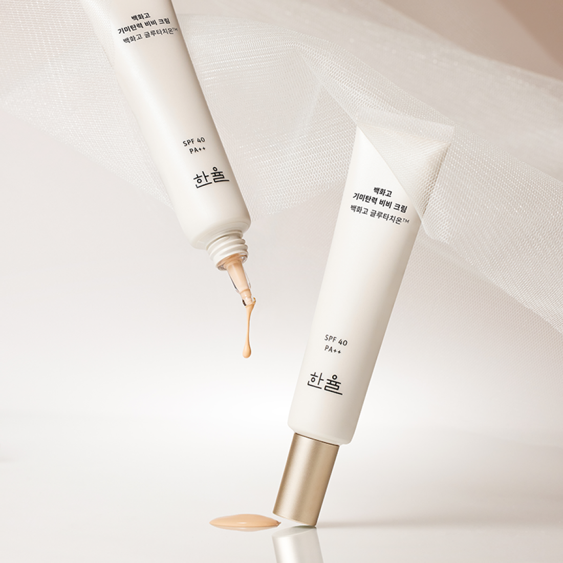 HANYUL Baekhwago Gimitanryuk BB Cream SPF40/PA++ 40ml, tubes et texture sur fond blanc, éclairage doux.