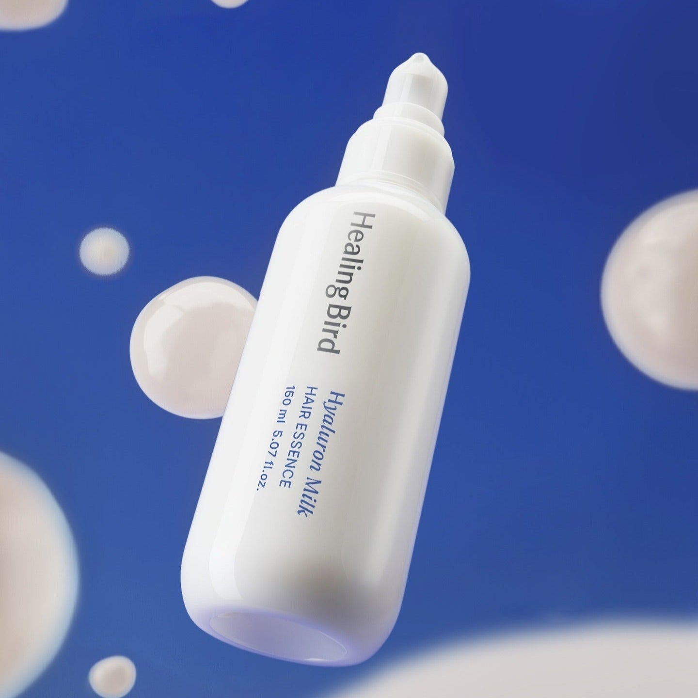 HEALING BIRD Hyaluronic Milk Hair Essence 150ml sur fond bleu avec bulles, soin capillaire hydratant efficace.