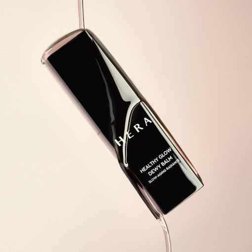Décris l'image en français mentionnant le produit, la marque et le contexte visuel avec HERA Healthy Glow Dewy Balm 10g