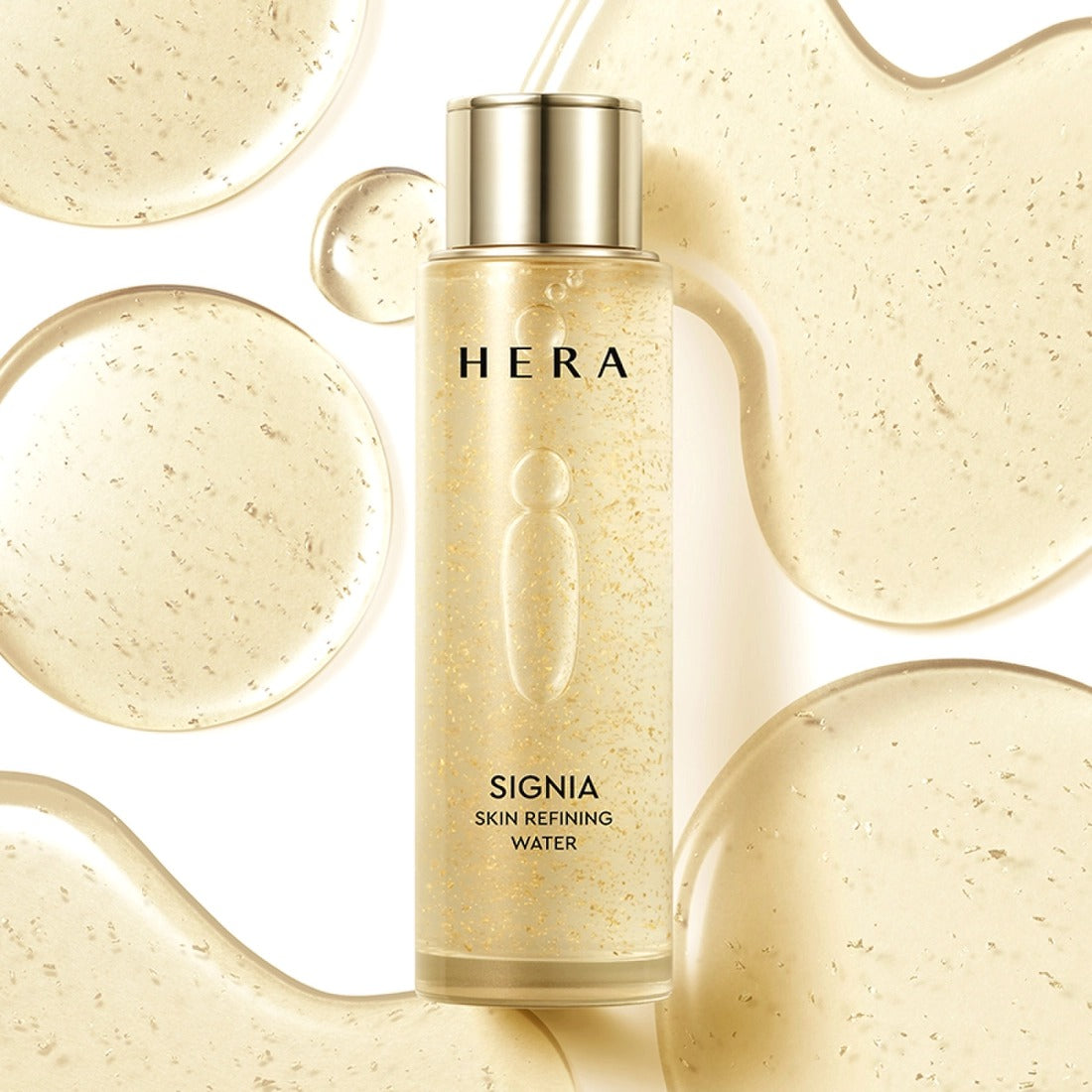 HERA Signa Skin refreshing Water 180ml de HERA, flacon doré sur fond beige, gouttes et éclats visuels
