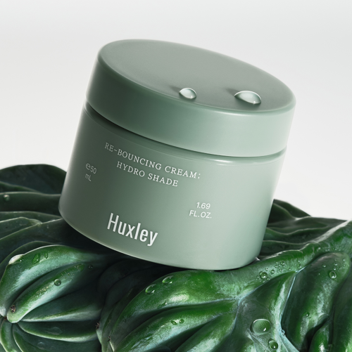 HUXLEY Rebouncing Cream Hydro Shade 50ml, pot vert sur feuilles, gouttes d’eau, marque Huxley, soin visage.