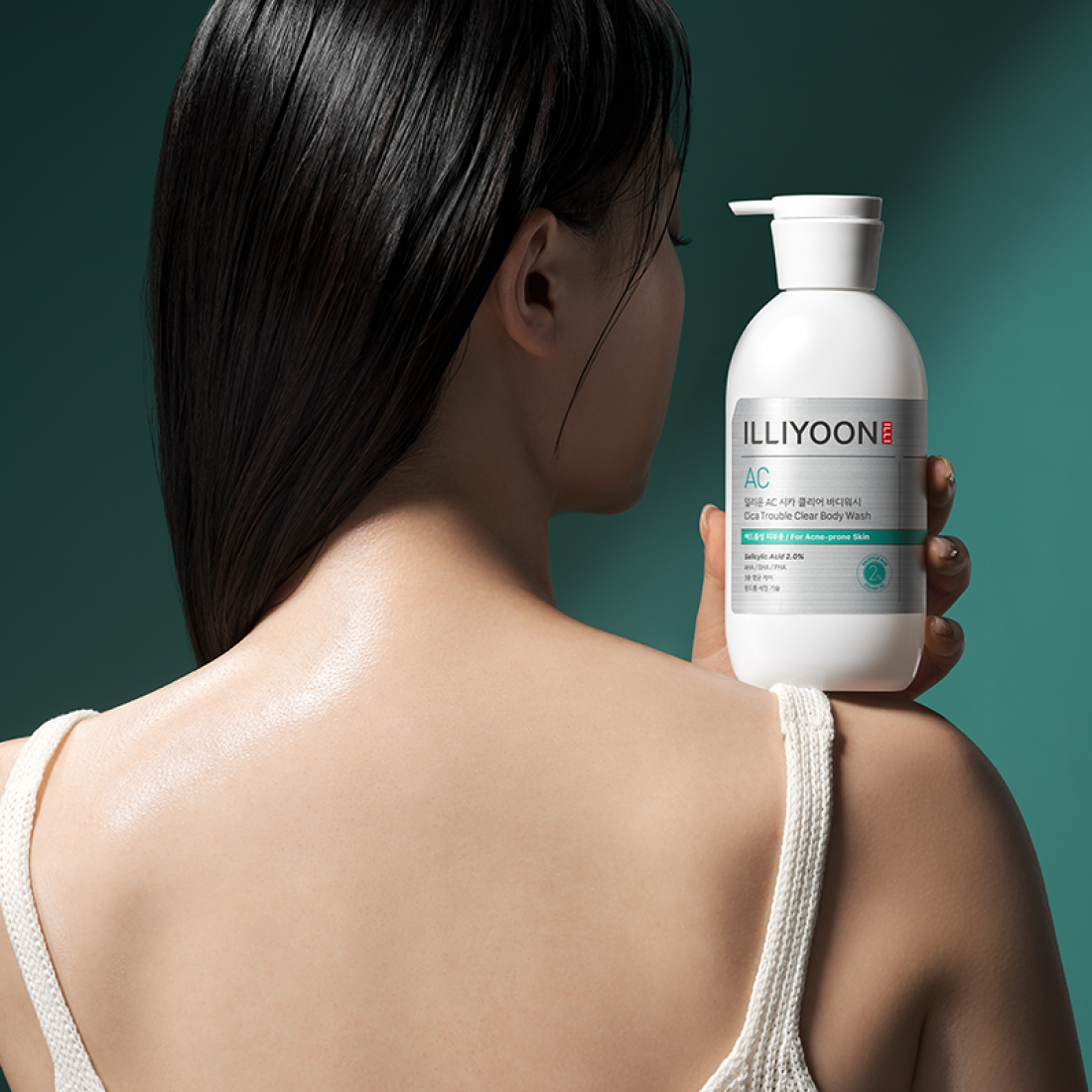 ILLiyoON Cica Acne Clear Body Wash 400ml, bouteille de soins pour peau aux tendances, sur fond vert avec personne en gros plan.