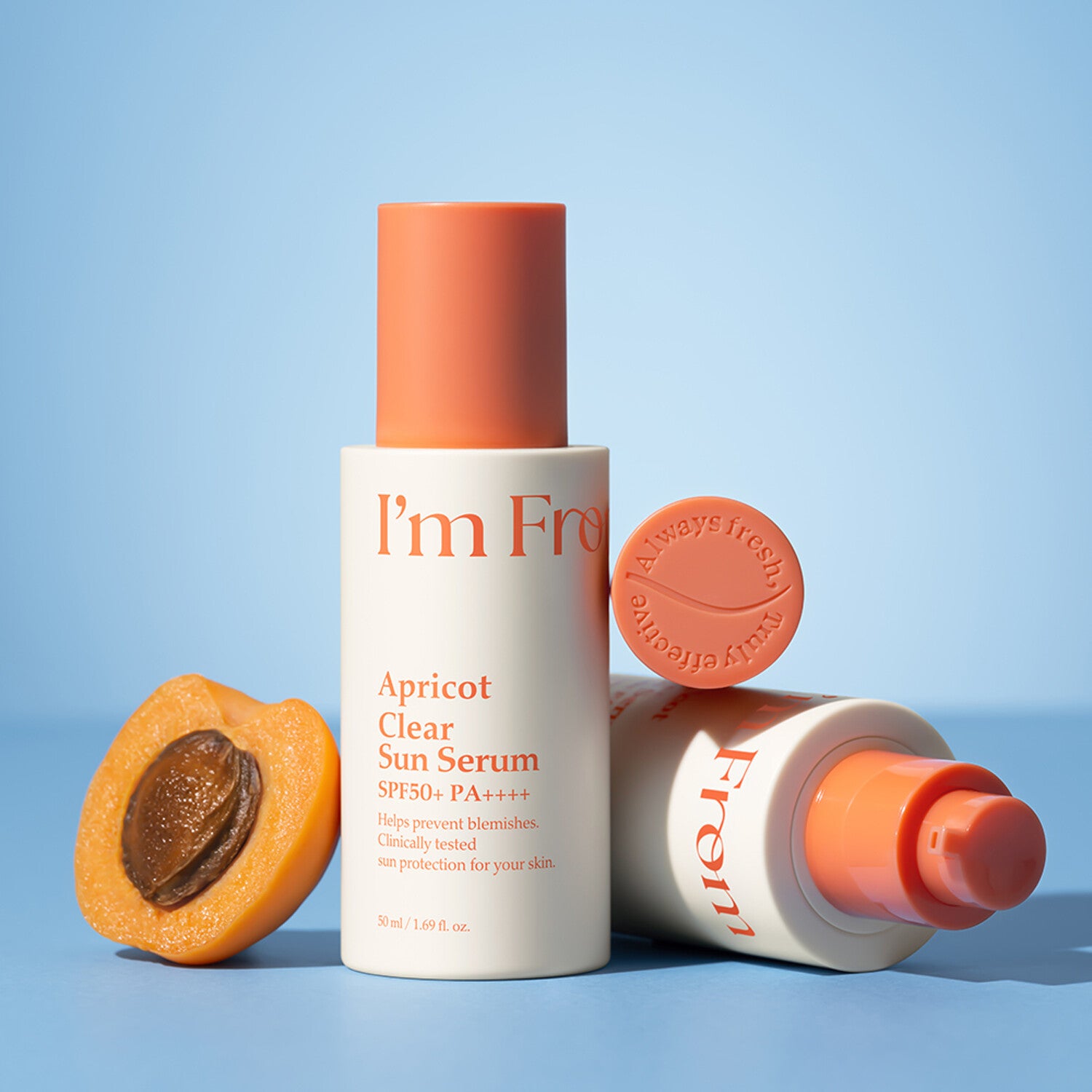 I'M FROM Apricot Clear Sun Serum 50ml, marque I’m From : flacon et crème posés sur fond bleu, abricots à côté.