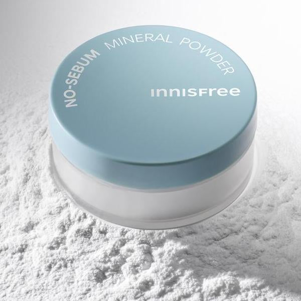 INNISFREE No Sebum Mineral Powder, boîtier bleu sur poudre minérale blanche, marque Innisfree en gros plan.