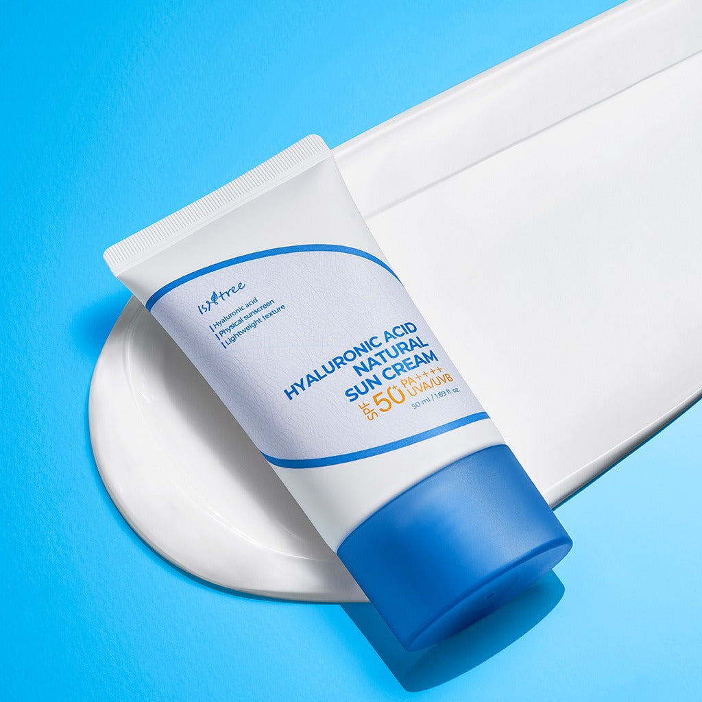 ISNTREE Hyaluronic Acid Natural Sunscreen 50ml, crème solaire hydratante, tube blanc et bleu sur fond ciel, photo produit.