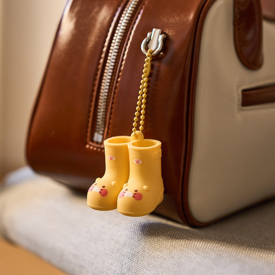KAKAO FRIENDS Rain boots keychain, porte-clés en bottes sous pluie, détail sur sac en cuir marron, marque KAKAO FRIENDS.