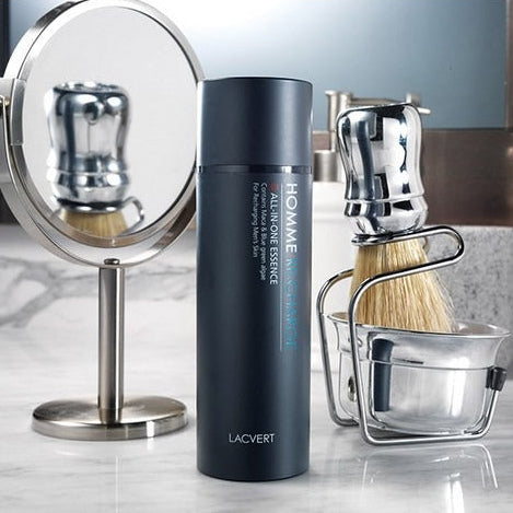 LACVERT Homme Recharge All-in-One Essence 150ml : flacon bleu sur coiffeuse, rasage et miroir, ambiance salle de bain.
