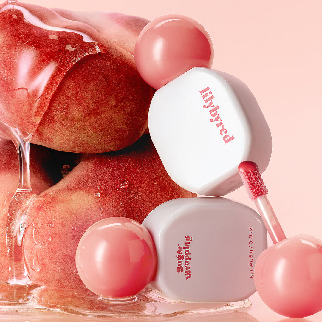 LILIBYRED Sugar Wrapping Tint Gloss avec texture fruitée, brillant à lèvres hydratant et intense, emballage élégant, pêche en arrière-plan.