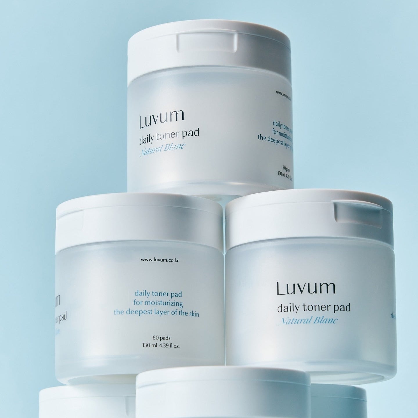 Décris l'image en français : LUVUM 1 Hyaluronic Acid Toner Pads 60 Sheets, marque Luvum, boîtes sur fond bleu clair.