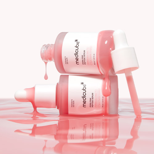 Décris l'image en français : MEDICUBE PDRN Pink Peptide Ampoule de medicube, flacons roses/rouges sur fond clair, style soins.