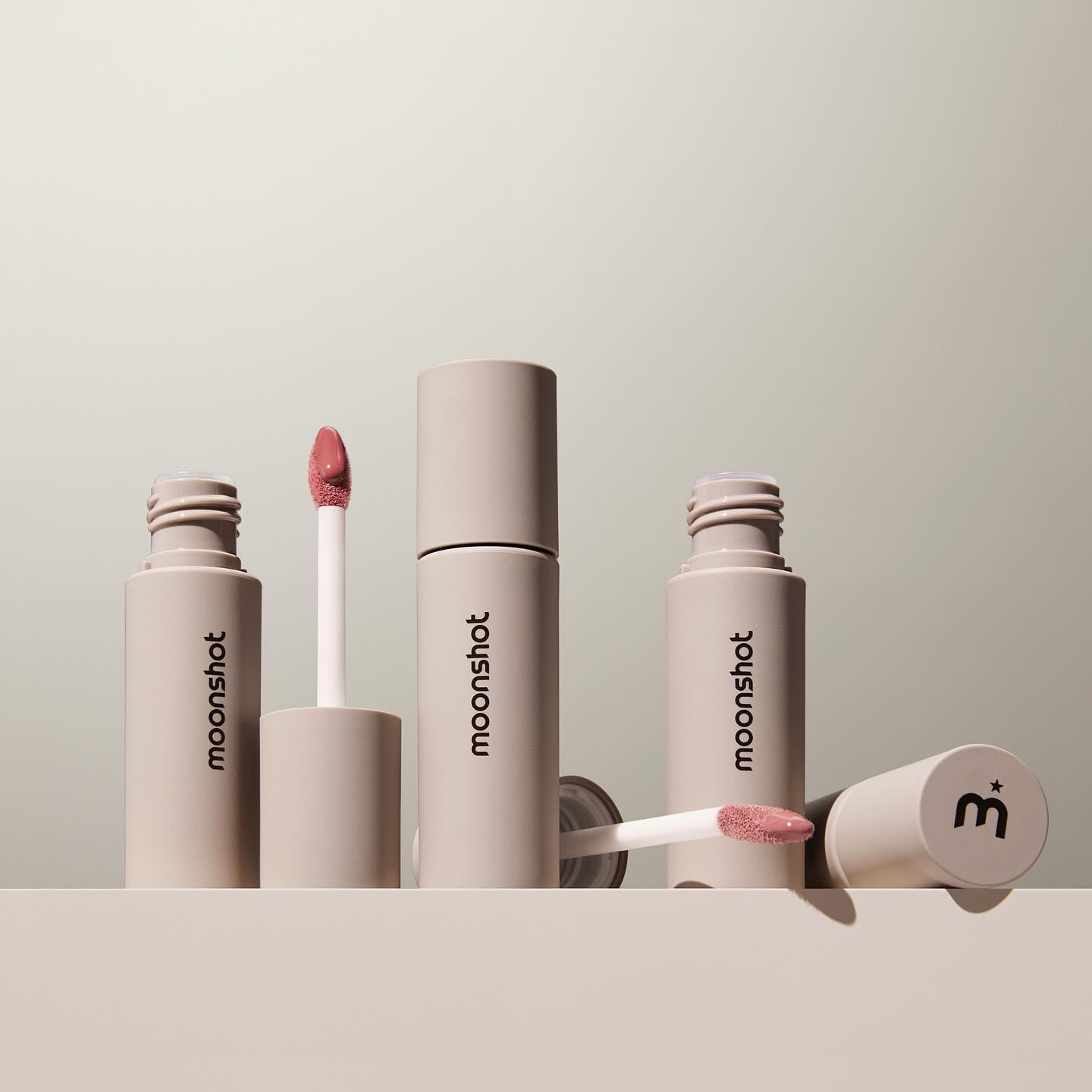 MOONSHOT Conscious Fit Melow Lip Tint, maquillage en tubes beige sur fond clair, marquage MOONSHOT visible