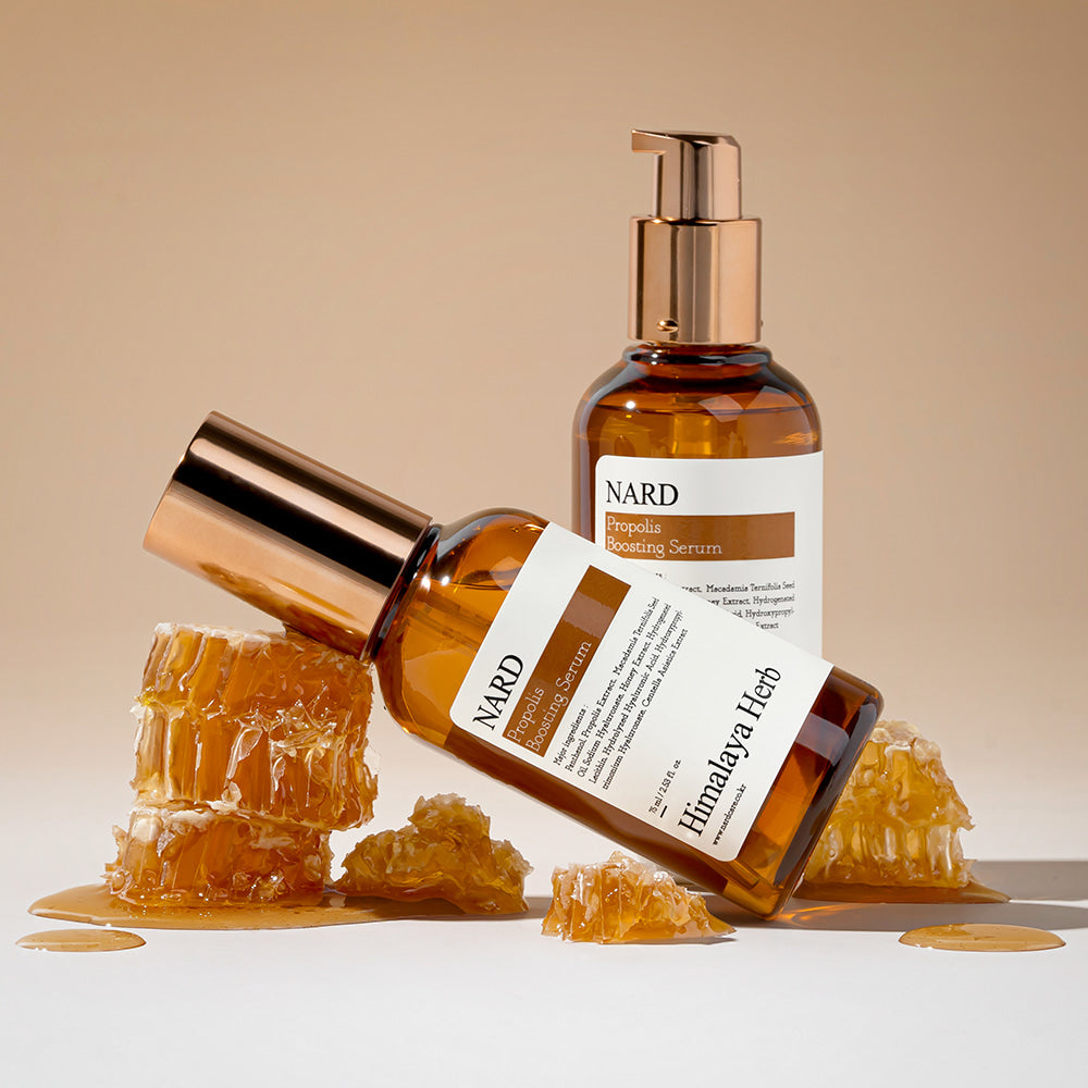 NARD Propolis Boosting Serum 75ml de NARD, flacon doré sur fond beige avec éclats de propolis, studio