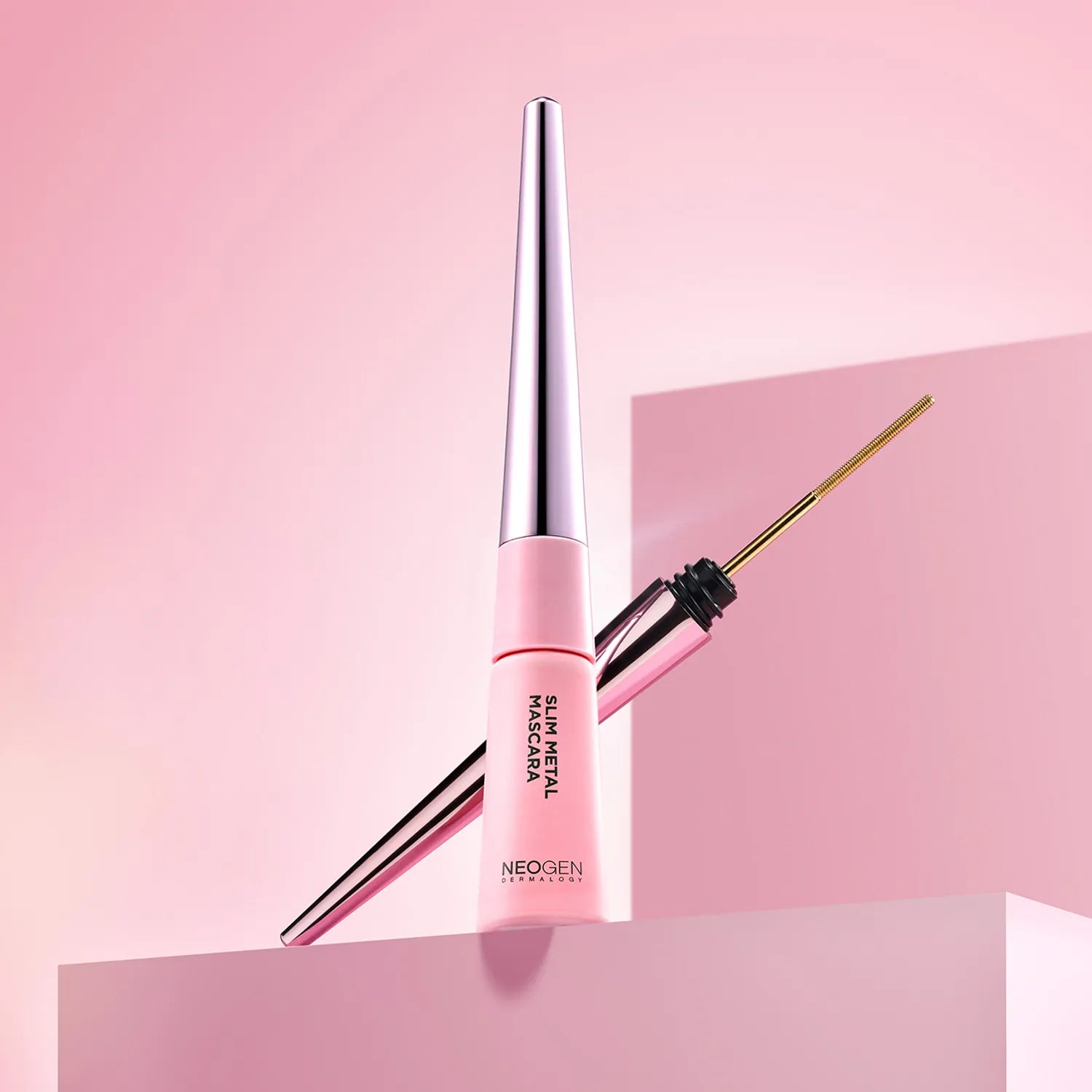 NEOGEN Slim Metal Mascara 6ml de NEOGEN, flacon et brosse sur fond rose tendance, maquillage yeux.