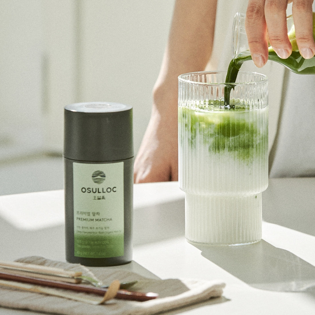 OSULLOC Premium Matcha 40g : pot matcha OSULLOC et verre de lait vert, ambiance cuisine lumineuse, français