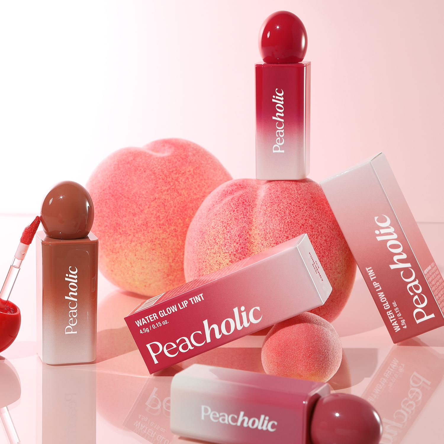 PEACHOLIC Water Glow Lip Tint de la marque Peacholic, flacons rouge sur fond rose, ambiance maquillage glow.