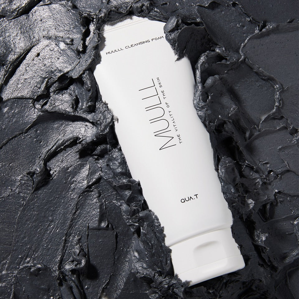 QUA-T Petavegan Large Capacity Cleansing Foam 250g, tube sur fond noir texturé, marque QUA-T visible.