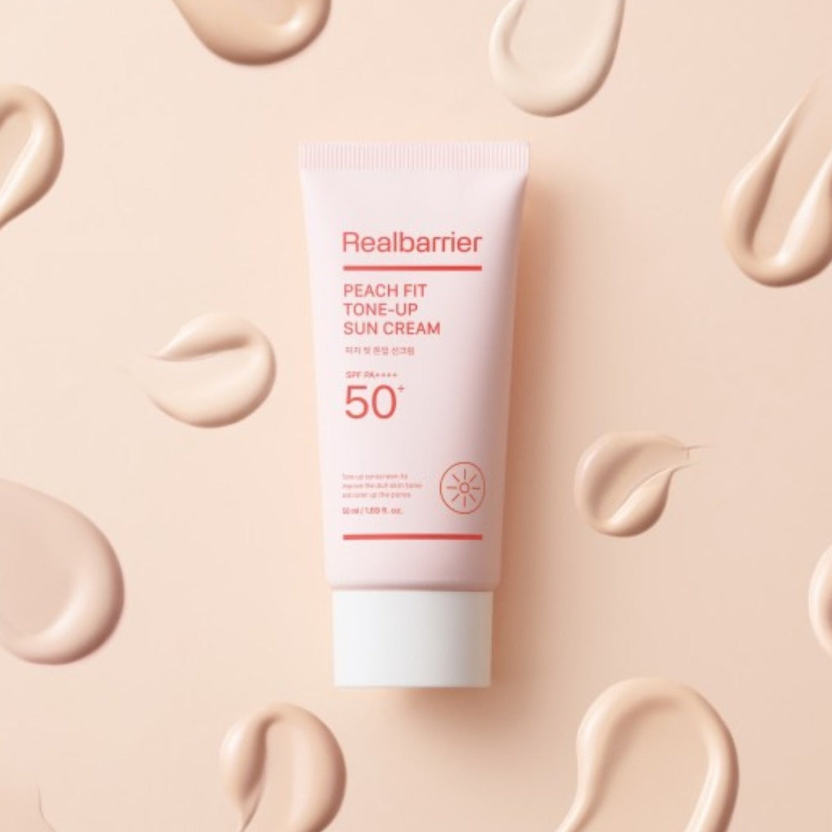 REAL BARRIER Peach Fit Tone-Up Sun Cream 50ml de Realbarrier, crème solaire pêche sur fond beige avec texture de crème.