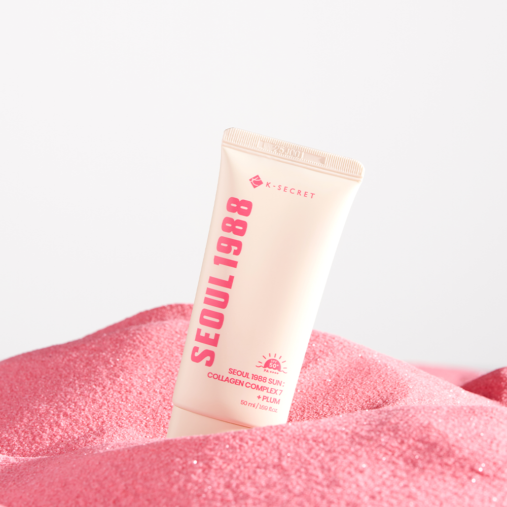 SEOUL 1988 Collagen Sun Lotion 50ml de K-Secret, sur fond blanc, posé sur une texture rose scintillante.