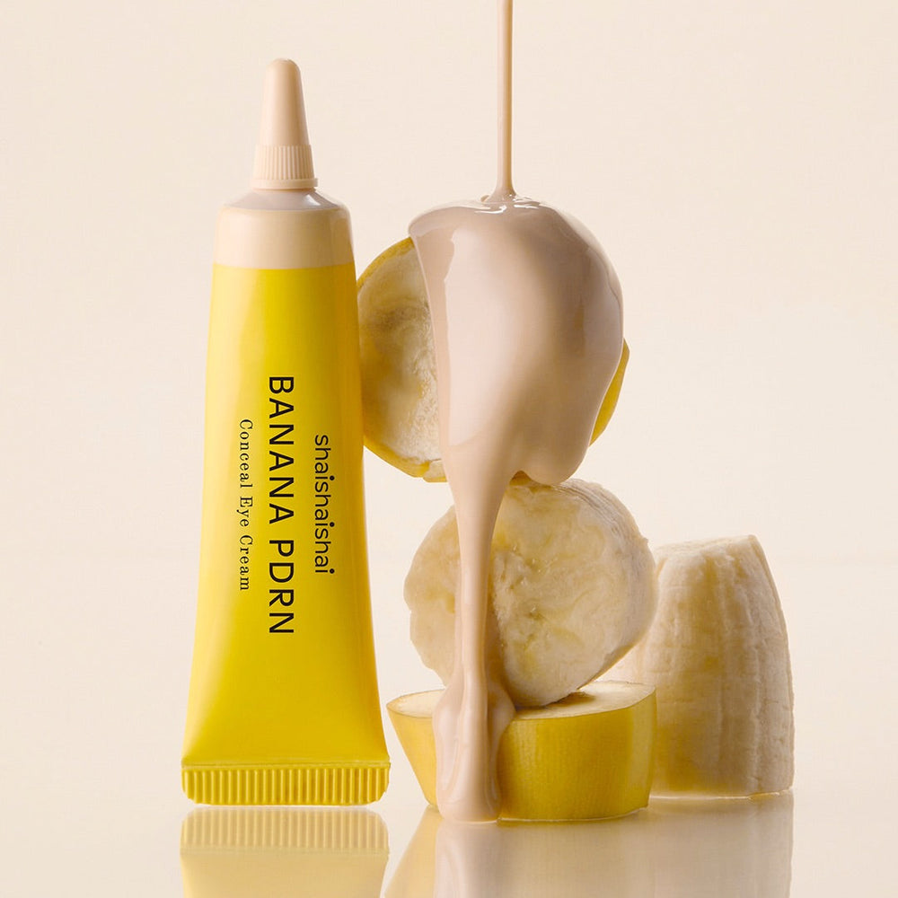 SHAISHAISHAI Banana PDRN Conceal Eye Cream 15ml : tube jaune sur fond crème, contexte beauté, marque SHAISHAISHAI.