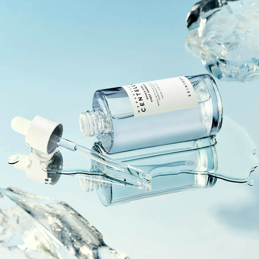 SKIN1004 Madagascar Centella Hyalu-Cica First Ampoule 100ml de la marque SKIN1004, flacon au fond bleu, éclaboussures d’eau