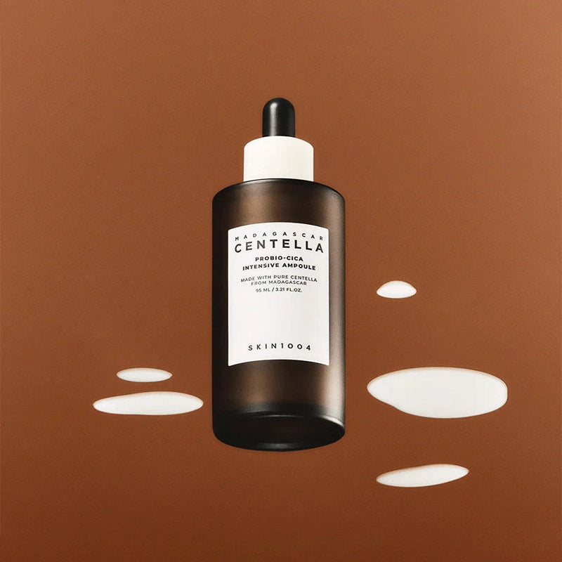 SKIN1004 Madagascar Centella Probio-cica Intensive Ampoule 50ml sur fond marron avec des éclaboussures blanches.